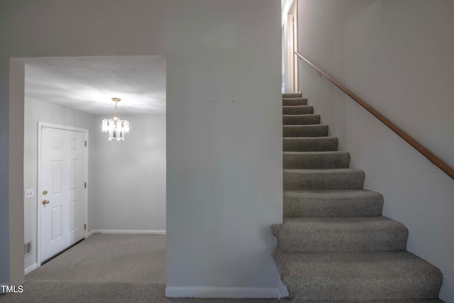 stairway featuring a chandelier, baseboards, and carpet