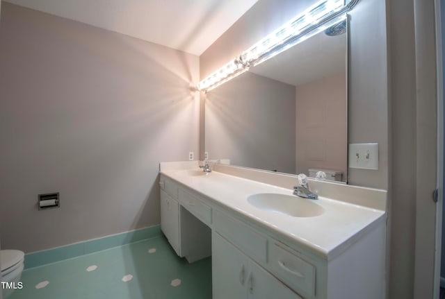 full bathroom featuring double vanity, toilet, baseboards, and a sink