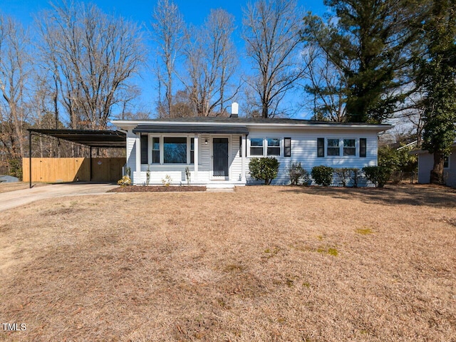 ranch-style home featuring a carport, a chimney, concrete driveway, and a front lawn