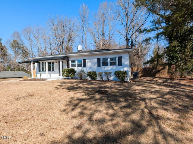 ranch-style house featuring cooling unit, a carport, a front yard, and fence