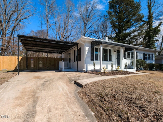 ranch-style house featuring a detached carport, driveway, and fence