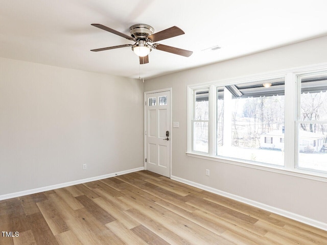 entrance foyer with baseboards, light wood-type flooring, a wealth of natural light, and ceiling fan