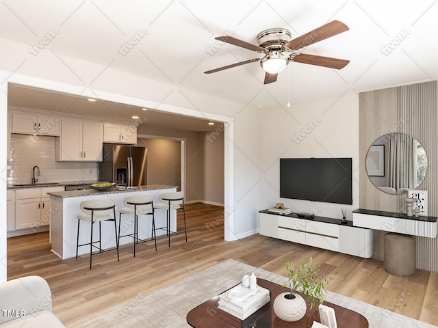 living room with light wood-style flooring and a ceiling fan