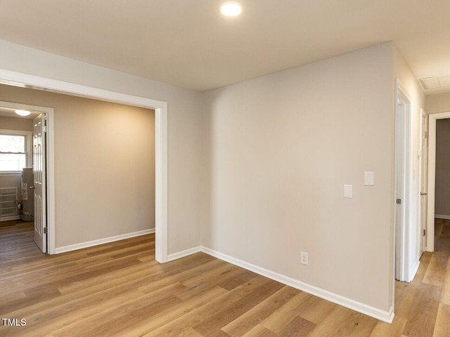 spare room featuring light wood-style flooring and baseboards