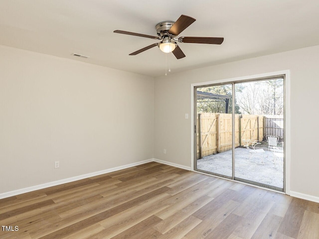 empty room featuring visible vents, baseboards, ceiling fan, and wood finished floors