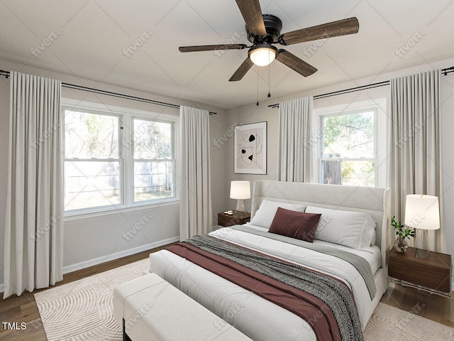 bedroom with baseboards, wood finished floors, and a ceiling fan