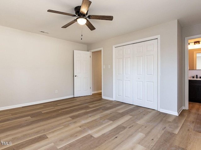 unfurnished bedroom featuring visible vents, ceiling fan, baseboards, wood finished floors, and a closet