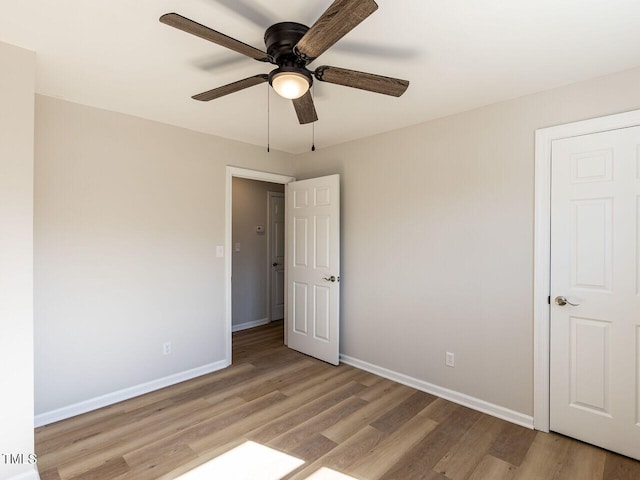 unfurnished bedroom featuring ceiling fan, light wood-style floors, and baseboards