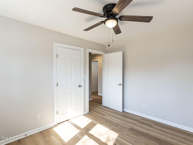 unfurnished bedroom with light wood-style flooring, baseboards, and ceiling fan