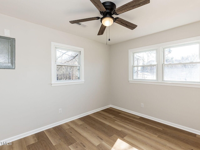 spare room featuring wood finished floors, visible vents, and a wealth of natural light