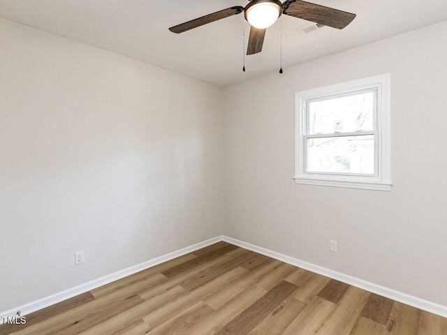 spare room with light wood finished floors, visible vents, baseboards, and ceiling fan