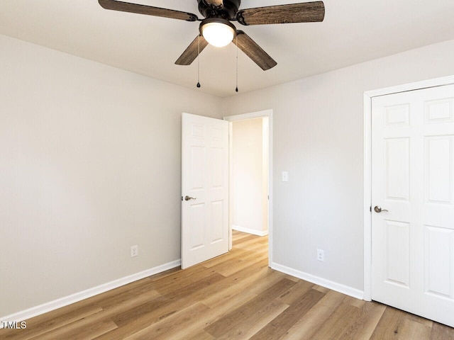 unfurnished bedroom featuring light wood-style flooring, baseboards, and ceiling fan