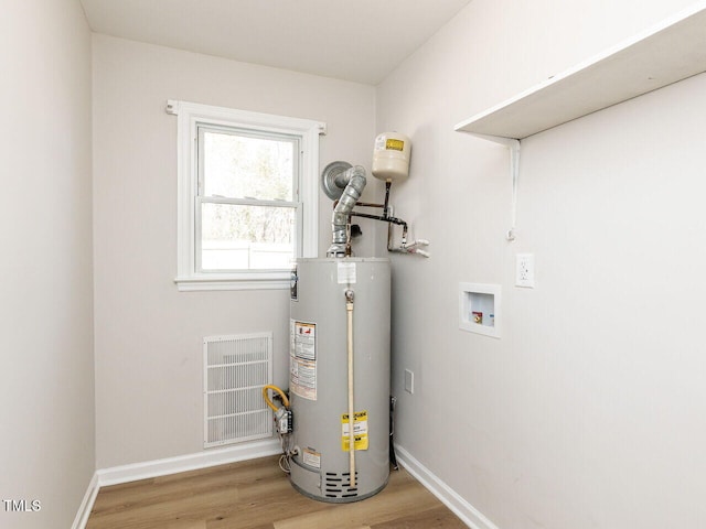 utilities featuring visible vents and gas water heater