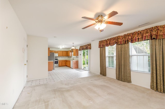 1009 Limeberry Ct, Clayton, NC 27520 - unfurnished living room with visible vents, a ceiling fan, light carpet, and a sink