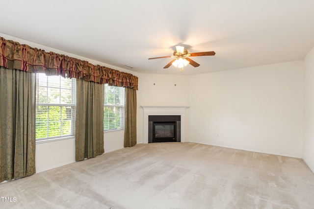 1009 Limeberry Ct, Clayton, NC 27520 - unfurnished living room featuring light carpet, a ceiling fan, a glass covered fireplace, and baseboards