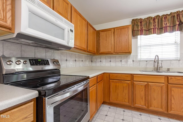 1009 Limeberry Ct, Clayton, NC 27520 - kitchen featuring a sink, brown cabinets, stainless steel range with electric cooktop, white microwave, and light countertops