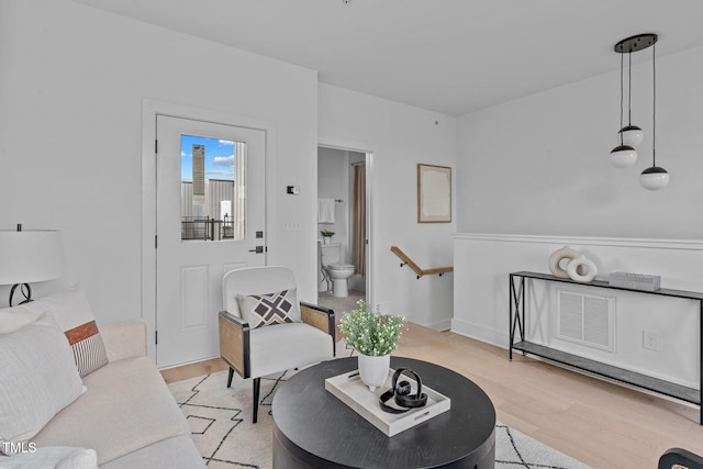 living area featuring light wood-type flooring and visible vents