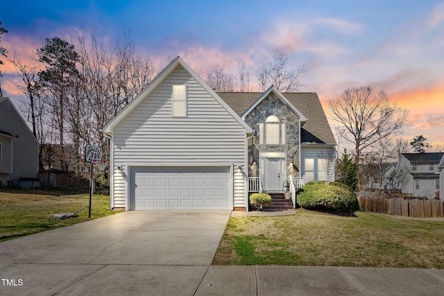 traditional-style home featuring a front lawn, fence, a garage, stone siding, and driveway