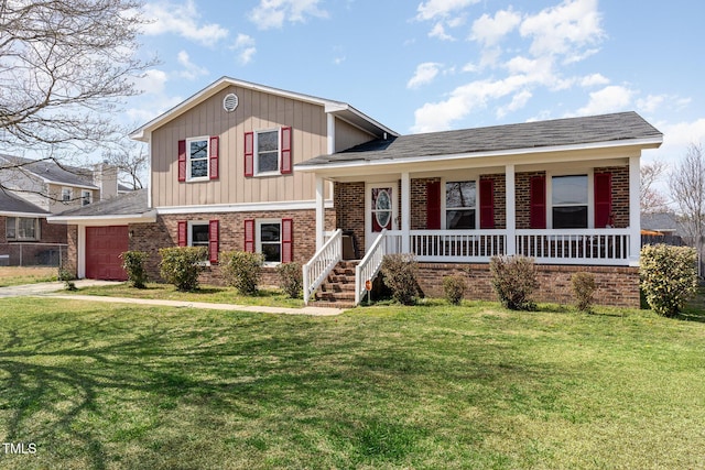 split level home featuring a front lawn, a porch, concrete driveway, an attached garage, and brick siding