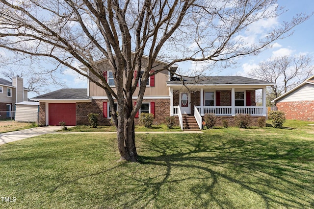 tri-level home featuring a front yard, driveway, a porch, a garage, and brick siding