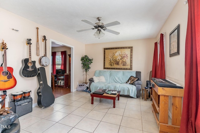 living room featuring light tile patterned floors, baseboards, and a ceiling fan