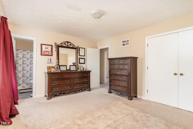 carpeted bedroom featuring baseboards, a closet, and a textured ceiling