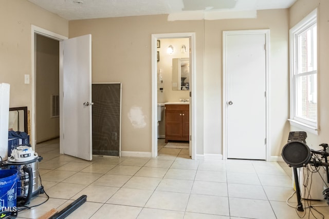 bedroom with visible vents, a sink, and light tile patterned floors