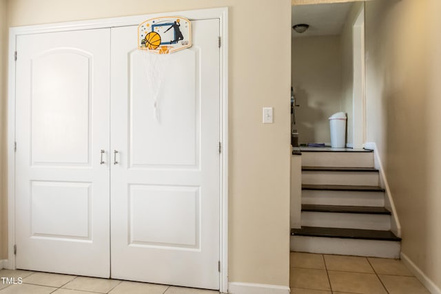 stairway featuring baseboards and tile patterned flooring
