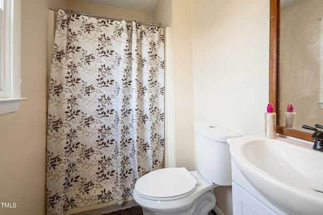 bathroom featuring vanity, toilet, and curtained shower