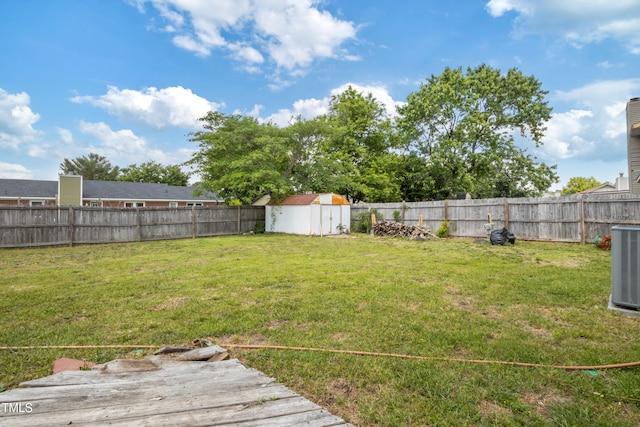 view of yard with a fenced backyard, an outbuilding, a storage shed, and cooling unit