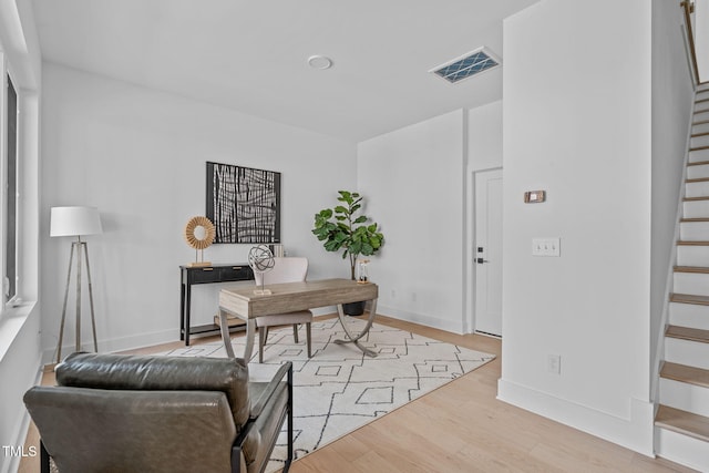 office space featuring visible vents, light wood-type flooring, and baseboards