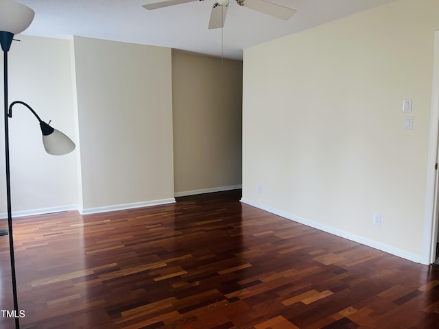 empty room with dark wood-style floors, baseboards, and ceiling fan