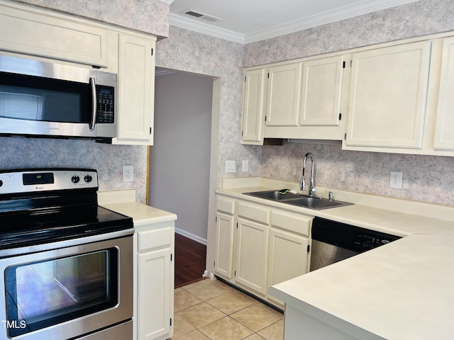 kitchen with wallpapered walls, light countertops, ornamental molding, stainless steel appliances, and a sink