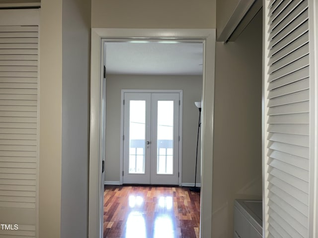 doorway with washing machine and dryer, french doors, baseboards, and wood finished floors