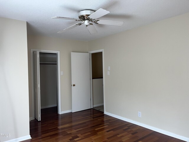 unfurnished bedroom featuring ceiling fan, wood finished floors, a closet, and baseboards