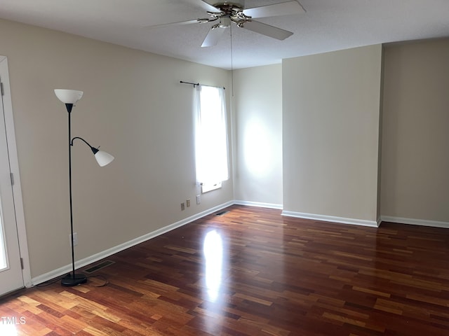 empty room featuring visible vents, baseboards, a ceiling fan, and wood finished floors