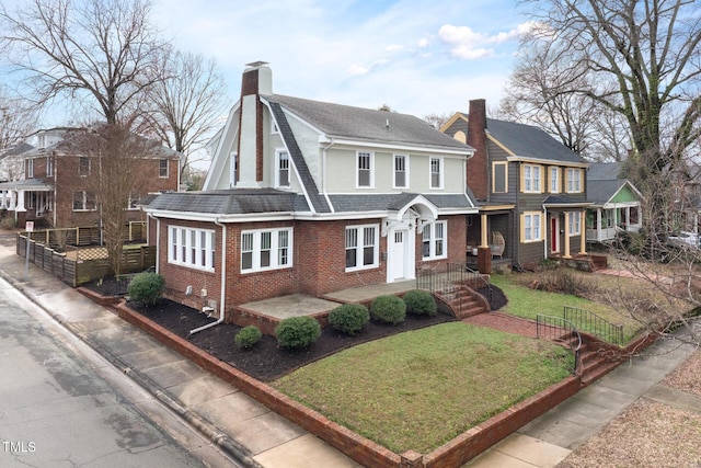 view of front of house with fence, roof with shingles, a chimney, a front lawn, and brick siding