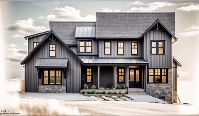 modern farmhouse featuring a standing seam roof, a porch, board and batten siding, and metal roof