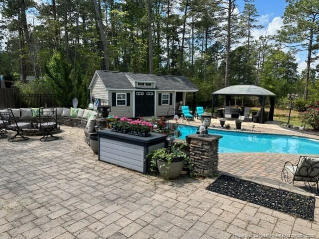 view of pool featuring an outbuilding, a fenced in pool, fence, an exterior structure, and a patio area