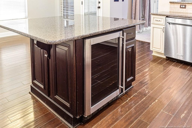 kitchen with light stone counters, wine cooler, dark wood-type flooring, and dishwasher