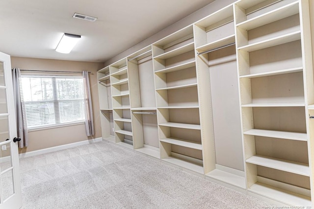 spacious closet featuring visible vents and carpet floors