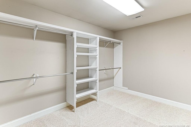 walk in closet with visible vents and carpet floors