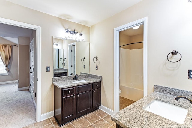 full bathroom with two vanities, baseboards, and a sink