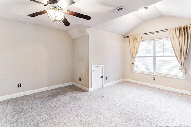 carpeted empty room with baseboards, visible vents, a ceiling fan, and lofted ceiling