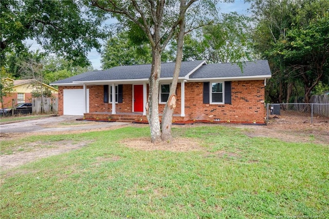 ranch-style house with brick siding, an attached garage, a front yard, and fence