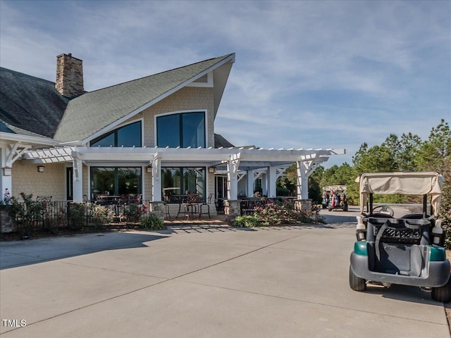 exterior space featuring a chimney, a patio area, and a pergola