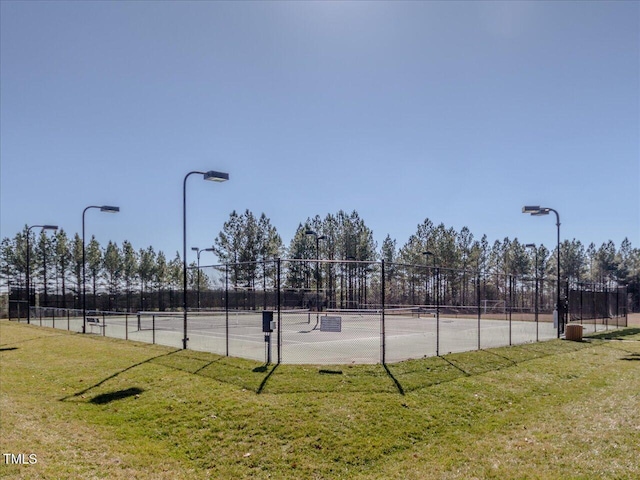 view of sport court with a yard and fence