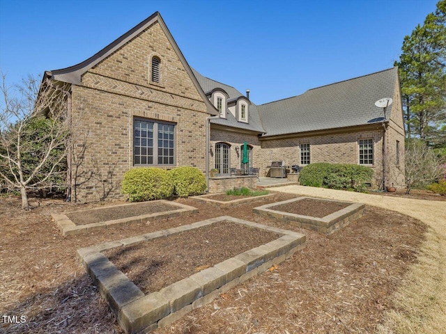 rear view of house with brick siding and french doors