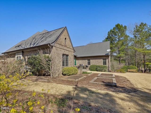 rear view of house with brick siding and a vegetable garden