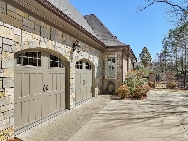 garage featuring concrete driveway and fence